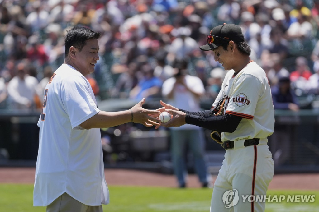 시구한 김태균 해설위원(왼쪽)과 공을 받은 이정후[AP=연합]